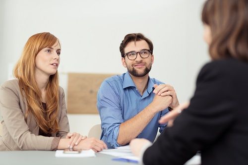 A woman and a man speaking to another woman.